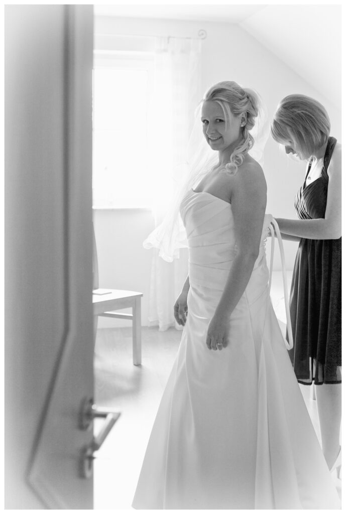 Hochzeitsbilder Ideen: Die Braut beim Ankleiden in schwarz-weiß und im Gegenlicht fotografiert