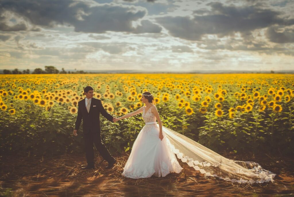 Brautleute vor einem Sonnenblumenfeld